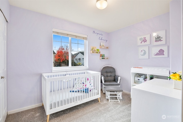 carpeted bedroom featuring a nursery area