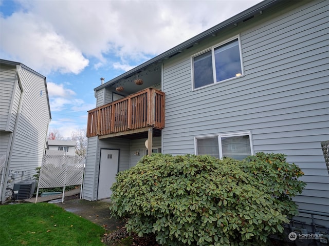 rear view of house with a balcony and central AC unit