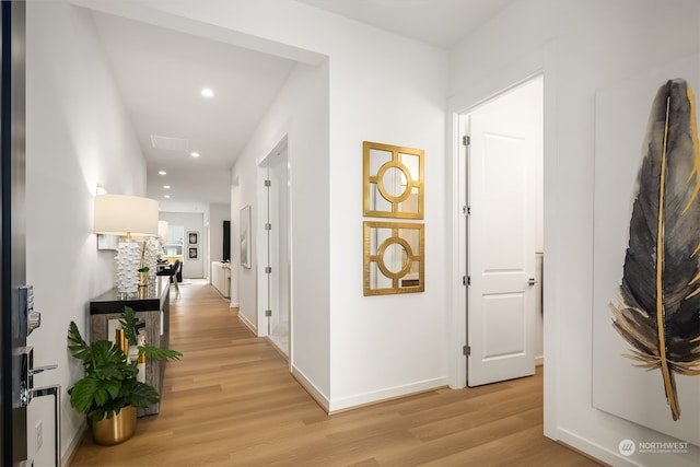 hallway with light hardwood / wood-style floors