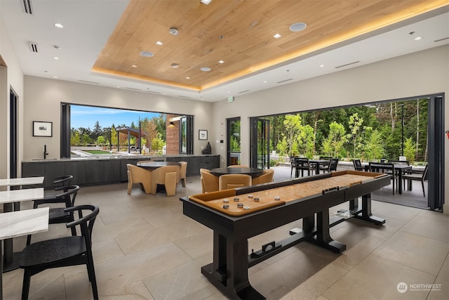 recreation room with a raised ceiling and wooden ceiling