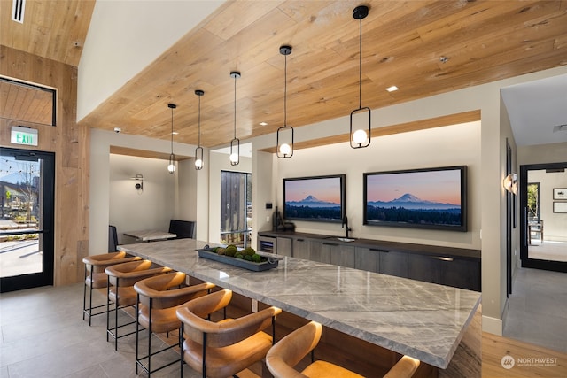 bar featuring light stone countertops, sink, wooden ceiling, high vaulted ceiling, and decorative light fixtures