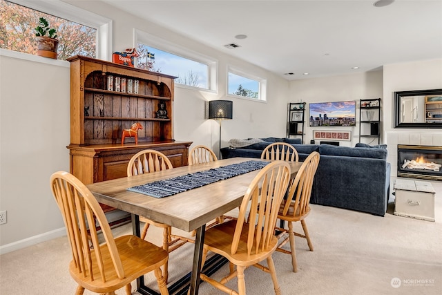 carpeted dining area featuring a fireplace