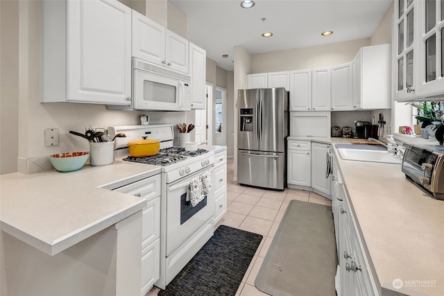 kitchen with white cabinets, white appliances, sink, and a wealth of natural light