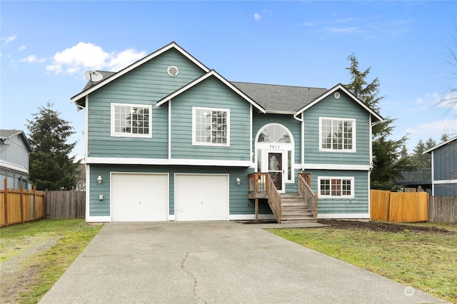 split foyer home featuring a garage and a front yard