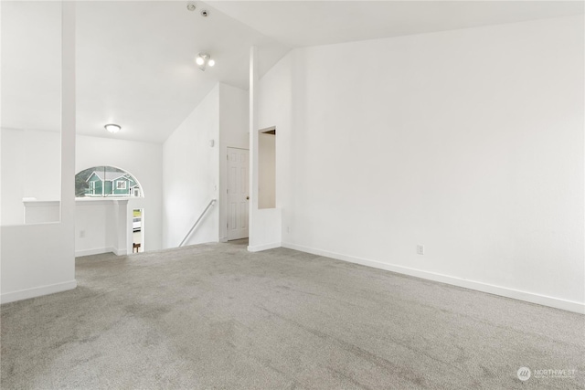 unfurnished living room with carpet and high vaulted ceiling