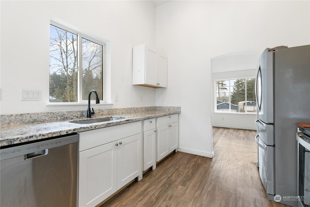 kitchen featuring white cabinets, light stone counters, and stainless steel appliances