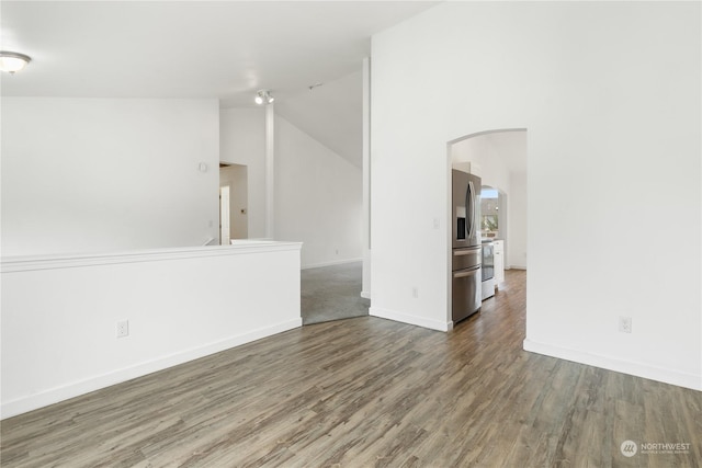 empty room with hardwood / wood-style floors and vaulted ceiling