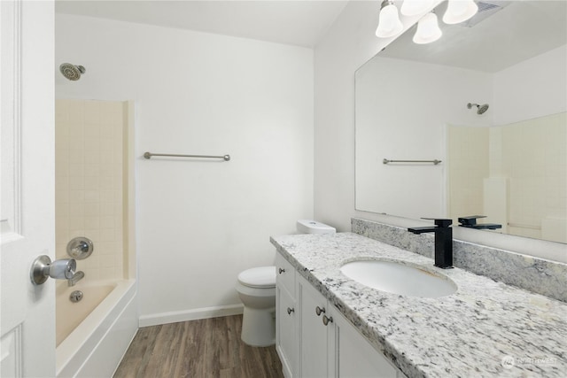 full bathroom featuring hardwood / wood-style floors, vanity, shower / bath combination, and toilet