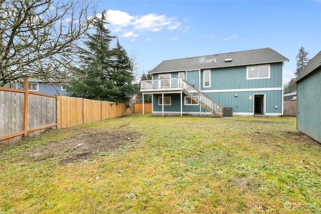 rear view of property featuring a lawn and a deck