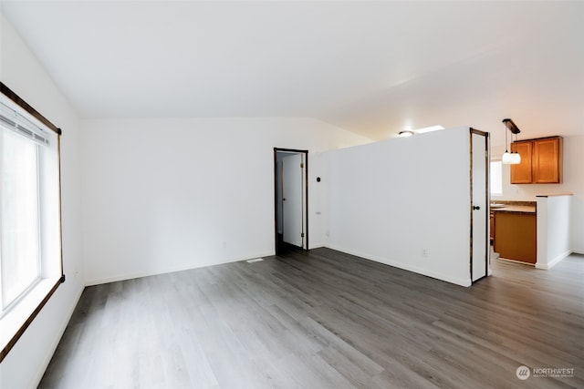 unfurnished room with plenty of natural light, dark wood-type flooring, and lofted ceiling