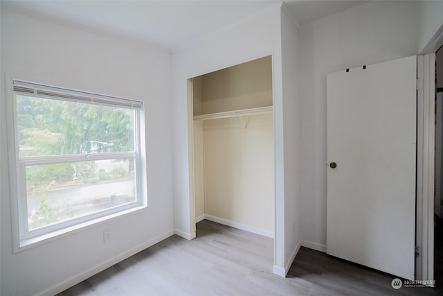 unfurnished bedroom featuring a closet and light hardwood / wood-style flooring