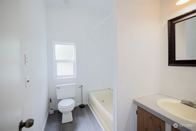 bathroom with vanity, hardwood / wood-style flooring, toilet, and a bathtub