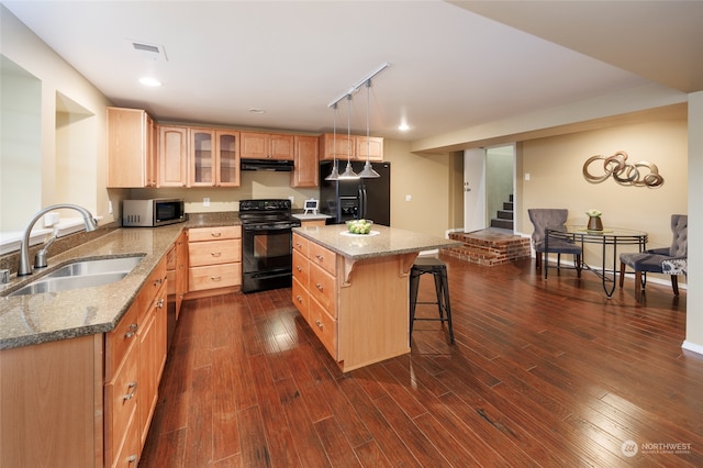 kitchen with black appliances, dark hardwood / wood-style floors, a center island, and sink