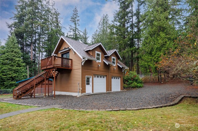 exterior space with a front yard, a garage, and a wooden deck