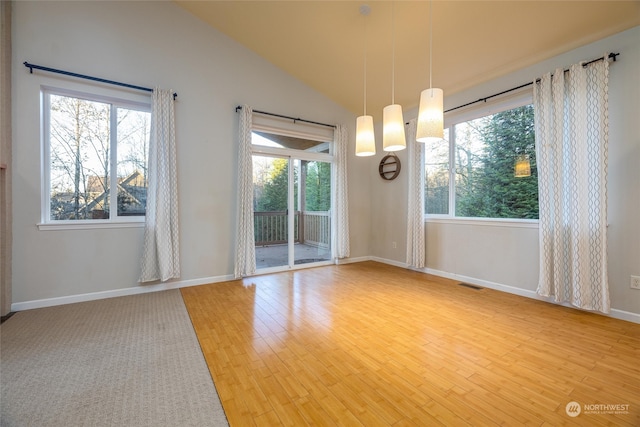 empty room featuring wood-type flooring and vaulted ceiling