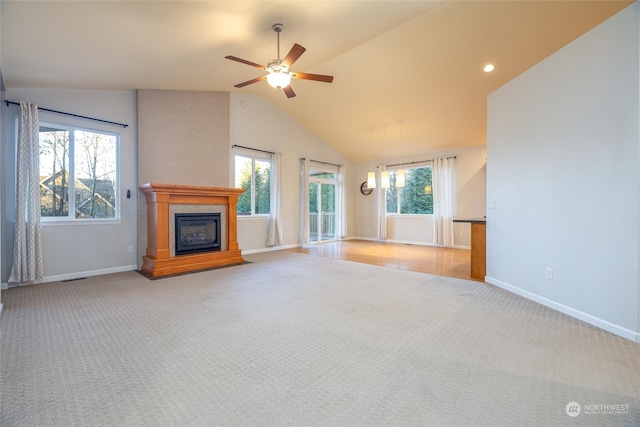 unfurnished living room featuring ceiling fan, light colored carpet, and vaulted ceiling