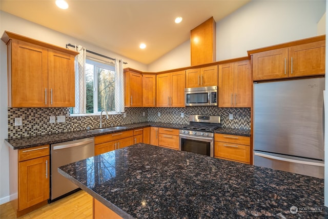 kitchen featuring sink, stainless steel appliances, light hardwood / wood-style flooring, lofted ceiling, and decorative backsplash