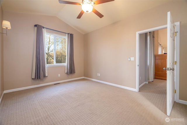 carpeted empty room featuring ceiling fan and lofted ceiling