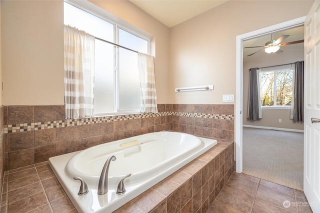 bathroom with a relaxing tiled tub, tile patterned floors, and ceiling fan