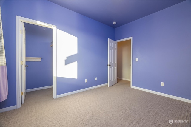 unfurnished bedroom featuring light carpet and a closet