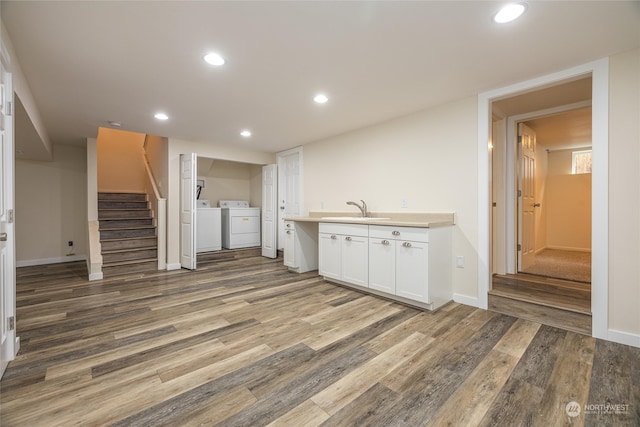 interior space with hardwood / wood-style flooring, separate washer and dryer, and sink