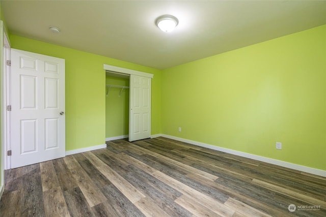 unfurnished bedroom featuring a closet and dark wood-type flooring