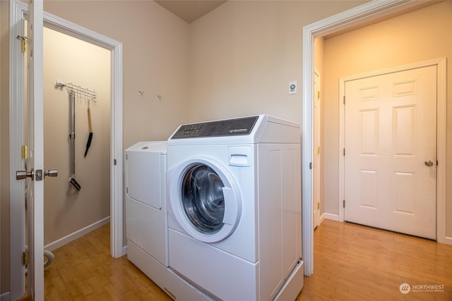 washroom featuring washing machine and dryer and light hardwood / wood-style floors