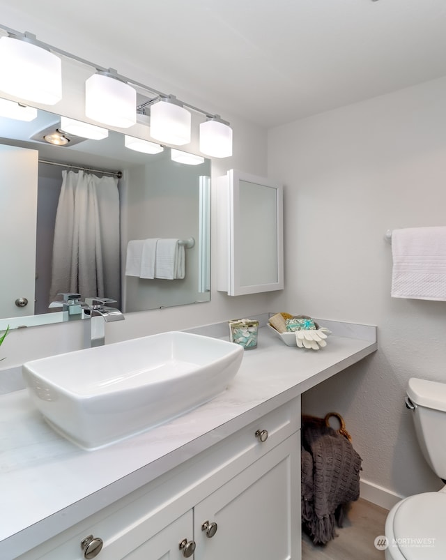 bathroom featuring hardwood / wood-style flooring, vanity, and toilet