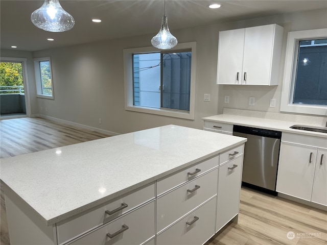 kitchen with stainless steel dishwasher, decorative light fixtures, white cabinetry, and light hardwood / wood-style flooring