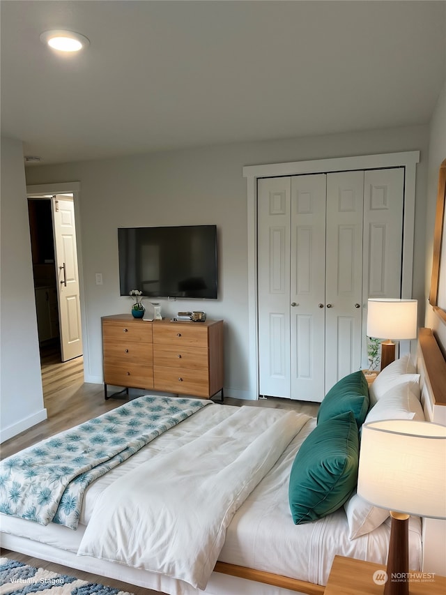 bedroom with light wood-type flooring and a closet