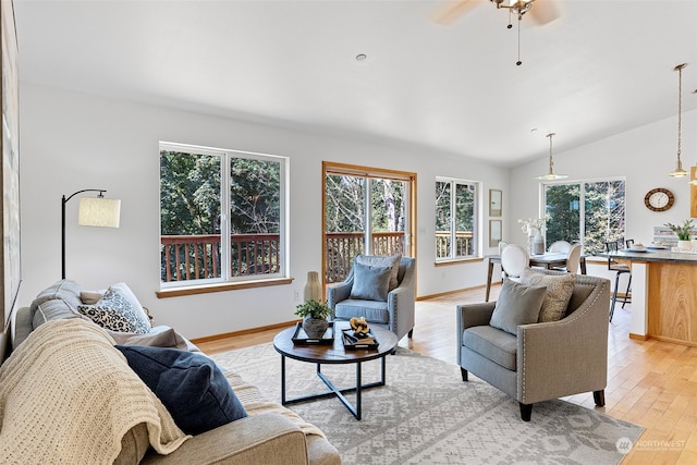 living room featuring ceiling fan, light hardwood / wood-style floors, and lofted ceiling