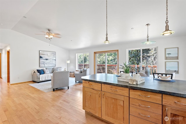 kitchen featuring light hardwood / wood-style floors, hanging light fixtures, lofted ceiling, and ceiling fan