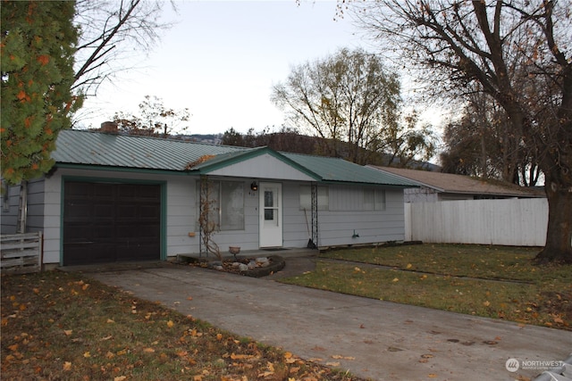 ranch-style home featuring a garage and a front lawn