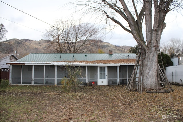 rear view of house with a mountain view and a sunroom