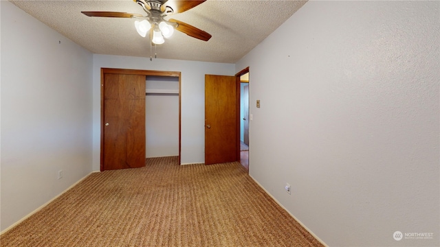 unfurnished bedroom with ceiling fan, a closet, light colored carpet, and a textured ceiling