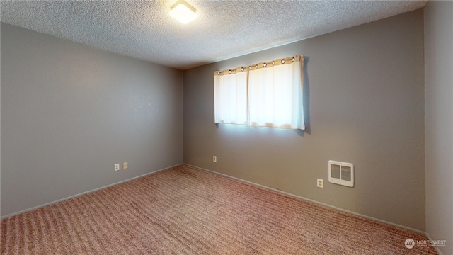 carpeted empty room with a textured ceiling