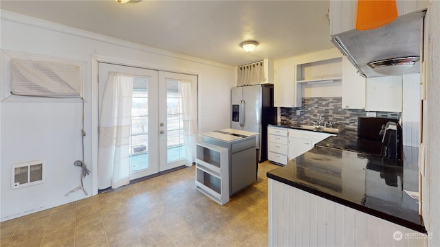 kitchen featuring french doors, stainless steel refrigerator with ice dispenser, sink, white cabinetry, and exhaust hood