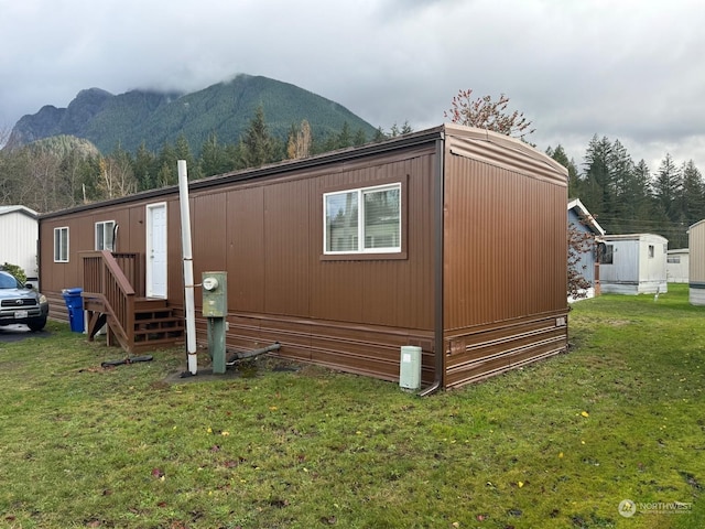 view of side of property featuring a mountain view and a yard