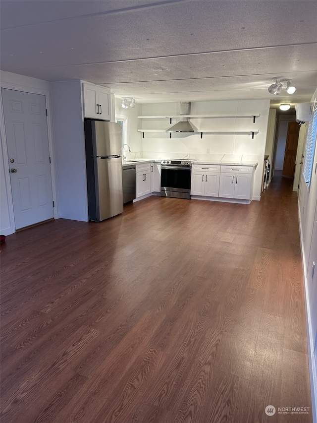 kitchen featuring appliances with stainless steel finishes, dark hardwood / wood-style flooring, extractor fan, sink, and white cabinetry