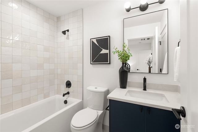 full bathroom featuring vanity, tiled shower / bath combo, and toilet