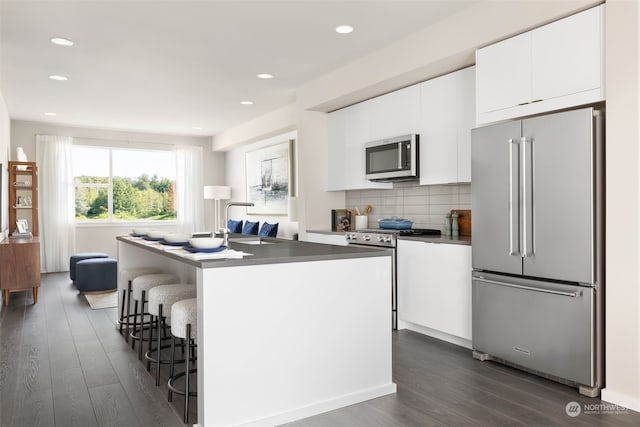 kitchen featuring appliances with stainless steel finishes, sink, a kitchen island with sink, and white cabinets