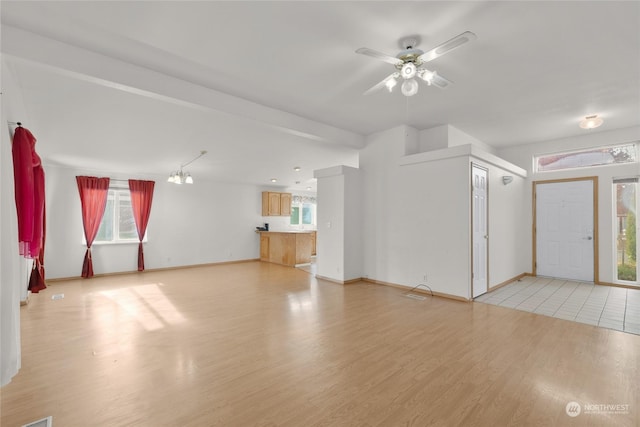 1100 S Rosewood Dr Unit 405, Ellensburg, WA 98926 - unfurnished living room featuring a ceiling fan, light wood-style floors, and baseboards