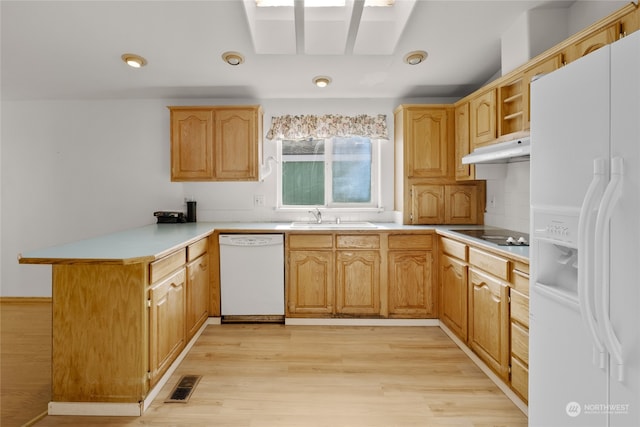 kitchen featuring white appliances, sink, a skylight, light hardwood / wood-style floors, and kitchen peninsula