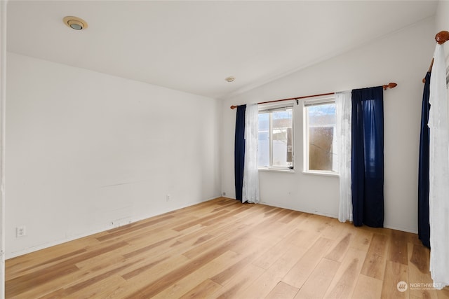 empty room with light hardwood / wood-style floors and lofted ceiling