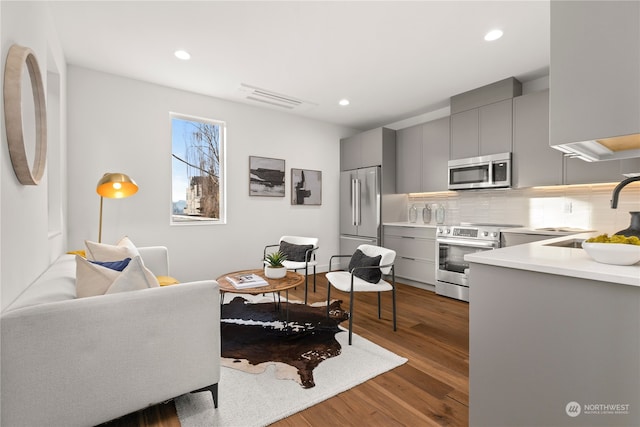 living room with dark hardwood / wood-style flooring and sink