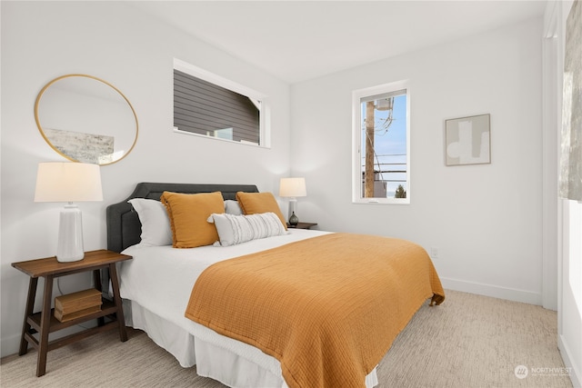 bedroom featuring baseboards and light colored carpet