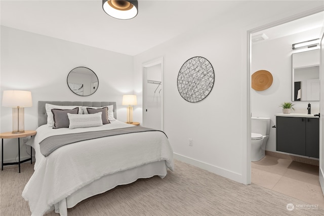 tiled bedroom with sink and ensuite bath