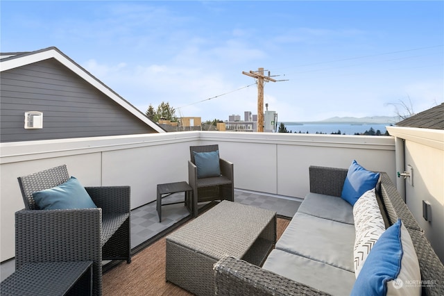 view of patio / terrace featuring a water view, a balcony, and an outdoor hangout area