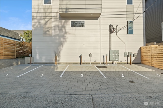 uncovered parking lot featuring basketball court and fence