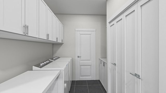 clothes washing area featuring cabinet space, separate washer and dryer, and dark tile patterned floors